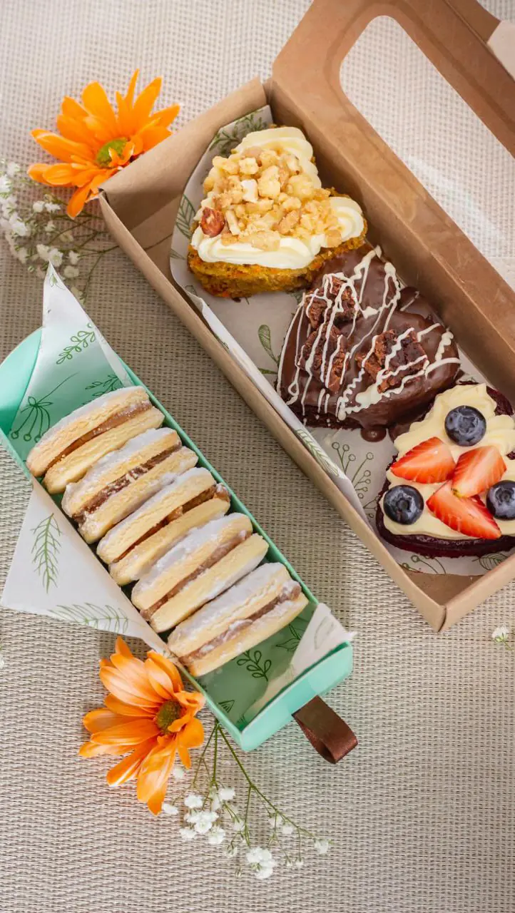 Cajas de regalo de La Moldería con alfajores, mini tortas y flores