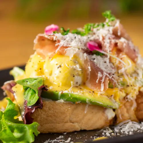 Huevos benedictinos con salsa holandesa, aguacate y jamón