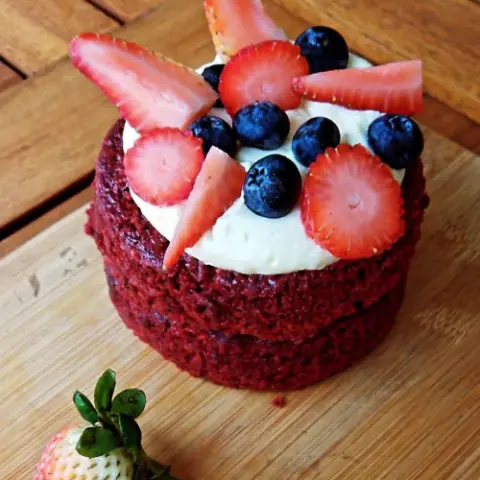 Torta red velvet con crema, fresas y arándanos
